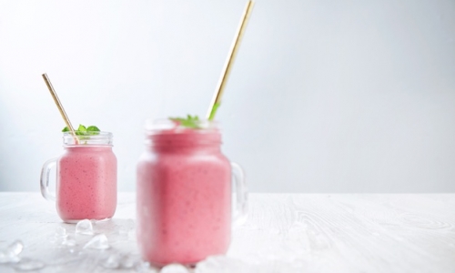 two-rustic-jars-with-fresh-blended-smoothie-from-yogur-berries-ice-isolated-wooden-table-white-backg